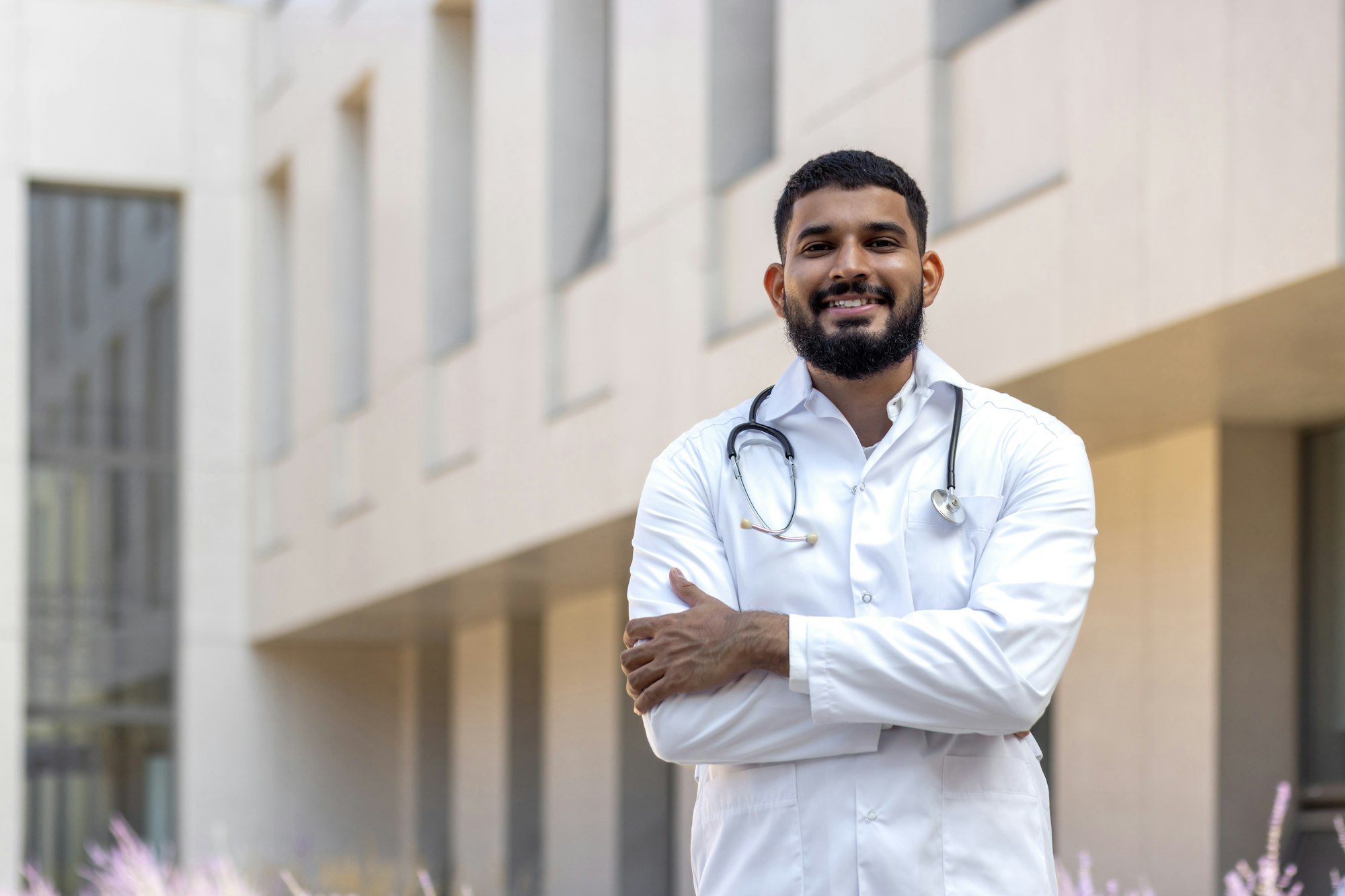 Portrait of a young doctor student, an intern standing outside the medical building and looking at